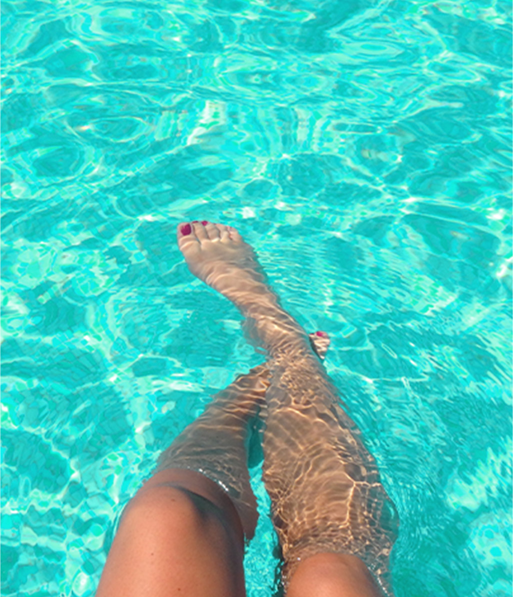 a pair of feet relaxing in a pool